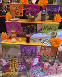 Display of colorful items including a bottle of Coca-Cola, flowers, and decorative objects on a shelf.
