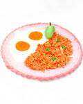 Artistic representation of a fish made from rice, eggs, and vegetables on a white background