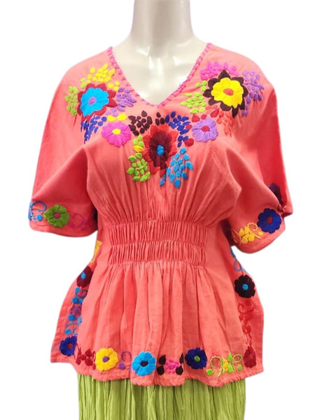 Colorful top with floral embroidery and green skirt on a mannequin against a white background